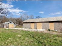 Exterior view of two unfinished outbuildings, boarded up at 2860 S Rybolt Ave, Indianapolis, IN 46241