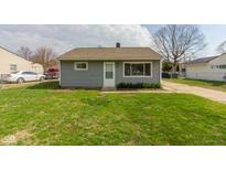 Cozy single-story home with gray siding and a well-manicured lawn and a paved drive at 380 Parkway St, Whiteland, IN 46184
