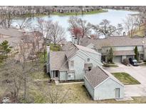 An aerial view shows the home's proximity to the water, detached garage, and the surrounding green spaces at 7160 Harbour, Indianapolis, IN 46240