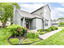 Charming two-story home featuring a shake siding, landscaped garden, and inviting front entrance at 7160 Harbour, Indianapolis, IN 46240