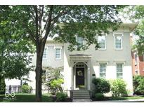 Charming two-story home with brick facade, landscaped yard, and mature trees providing shade at 12652 Meeting House Rd, Carmel, IN 46032
