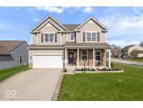 Charming two-story home with a well-manicured lawn and a two car garage and covered porch at 15152 Fallen Leaves Ln, Noblesville, IN 46060