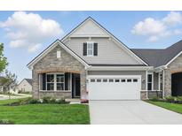 Charming single-story home featuring stone and gray siding, a two-car garage, and manicured lawn at 16955 Cole Evans Dr, Noblesville, IN 46060