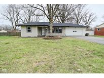 Charming ranch-style home featuring stone accents, black trim, and a well-maintained lawn at 2750 Kristen E Dr, Indianapolis, IN 46218