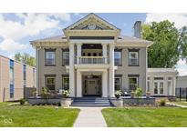 Stately two-story home with elegant columns and landscaped front yard, offering timeless curb appeal and charm at 3447 Washington Blvd, Indianapolis, IN 46205