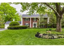 Charming two-story brick home boasts a landscaped yard, a covered porch, and classic architectural details at 650 Forest Blvd, Indianapolis, IN 46240