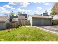 Exterior view of the condo building with a two-car garage and well-maintained green lawn on a sunny day at 652 Blossom Dr, Avon, IN 46123