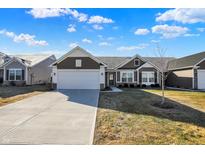 Charming single-story home with a two-car garage, neat landscaping, and a welcoming facade at 7111 Lillian Pl, Cumberland, IN 46229