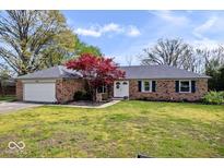 Charming brick home featuring a well-manicured lawn, beautiful landscaping, and an attached two-car garage at 7263 Hidden Valley Dr, Plainfield, IN 46168