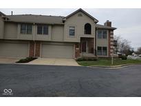 Charming townhome featuring a brick facade, attached garage, and well-maintained landscaping at 8955 Stonegate Rd # A, Indianapolis, IN 46227