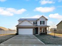 Inviting two-story home featuring a two-car garage, landscaped yard, and classic architectural details at 13211 N Landing W Cir, Camby, IN 46113