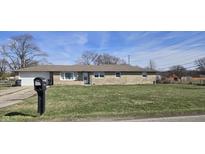 Ranch home with a stone facade, attached garage, and well-maintained front lawn at 3002 W 53Rd St, Anderson, IN 46011