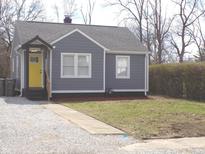 Charming home featuring a yellow door and gray siding and a well maintained landscape at 3323 E 36Th St, Indianapolis, IN 46218