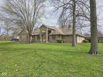 Charming single-story brick home featuring mature trees and a well-manicured lawn at 4808 N Camelot Dr, Muncie, IN 47304
