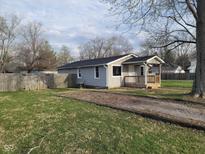 Charming single-story home with a covered porch and a spacious yard enclosed by a wooden fence at 509 N Home Ave, Mooresville, IN 46158