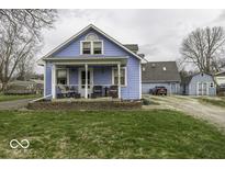 Charming blue home with a cozy front porch and seating, perfect for enjoying the outdoors at 5210 W Caven St, Indianapolis, IN 46241