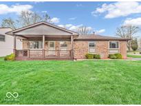 Charming single-story brick home featuring a covered front porch and a well-manicured lawn at 66 Coronado Rd, Indianapolis, IN 46234