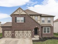 Charming two-story home featuring a brick facade, arched entryway, and a spacious two-car garage at 7730 Imperial Eagle Dr, Zionsville, IN 46077