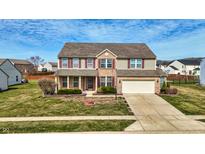 Charming two-story home featuring a brick facade, attached garage, and well-maintained lawn at 8358 Balmoral Dr, Avon, IN 46123