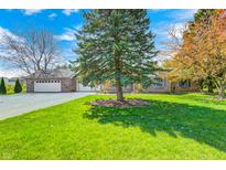 Charming single-story brick home with lush lawn, mature trees, and a detached two-car garage at 901 W 250 N, Lebanon, IN 46052