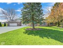 Charming brick home with a well-manicured lawn, mature trees, and a spacious driveway leading to an attached garage at 901 W 250 N, Lebanon, IN 46052