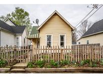 Charming exterior featuring a peaked roof, picket fence and garden beds with tulips at 902 Villa Ave, Indianapolis, IN 46203