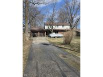 Two-story home featuring a brick facade, two-car garage, and a long, cracked driveway at 930 Charlene Ln, Anderson, IN 46011