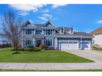 Charming two-story home featuring a three-car garage, manicured lawn, and inviting curb appeal at 1043 Palomar Dr, Westfield, IN 46074