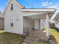 Charming single-Gathering home featuring a covered front porch, light gray siding, and a well-maintained lawn at 1313 W Memorial Dr, Muncie, IN 47302