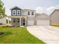 Charming two-story home featuring a brick facade and a spacious three-car garage at 211 Ames Dr, Whiteland, IN 46184