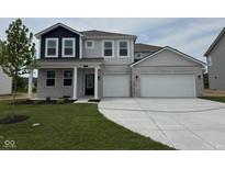 Inviting two-story home featuring a brick facade, a two-car garage, and a well-manicured lawn at 211 Ames Dr, Whiteland, IN 46184
