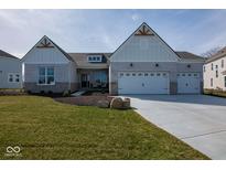 Charming home with white brick, complemented by a three car garage and well-manicured lawn at 4034 Saddle Club S Pkwy, Bargersville, IN 46106