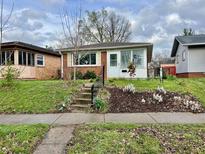 Charming brick home with a well-maintained front yard, flower beds, and a inviting entrance at 4151 Bowman Ave, Indianapolis, IN 46227