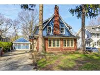Charming home with a red brick facade, blue siding and a detached two car garage at 420 N Irvington Ave, Indianapolis, IN 46219