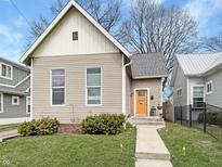 Charming home featuring a neat front yard and a brightly colored front door at 430 Parkway Ave, Indianapolis, IN 46225