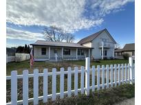 Charming two story home featuring a covered porch, white picket fence, and a classic architectural style at 529 E Jackson St, Martinsville, IN 46151