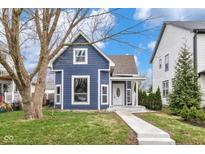 Charming blue two-story home featuring a welcoming front porch and a well-maintained lawn at 555 N Hamilton Ave, Indianapolis, IN 46201