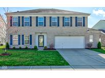 Charming two-story home with a well-manicured lawn and a two-car garage and blue shutters on the windows at 5845 Skyward Ln, Indianapolis, IN 46234