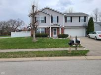 Charming two-story home with a well-manicured lawn, lovely landscaping, and inviting entrance at 7497 Grandview Dr, Avon, IN 46123