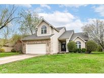 Charming two-story home features a manicured lawn and attached two car garage at 10516 Beacon Ln, Indianapolis, IN 46256