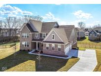 Stunning new construction home featuring brick and siding accents, a three car garage and well manicured lawn at 11392 Gammel Pl, Fishers, IN 46040