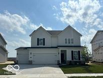 Inviting two-story home with a three-car garage, neutral siding, black shutters and a manicured lawn at 16441 Mount Logan Rd, Noblesville, IN 46060