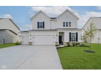 Charming two-story home boasts a three car garage and meticulously manicured lawn at 16441 Mount Logan Rd, Noblesville, IN 46060