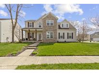 Charming two-story home with brick accents, covered front porch, and well-manicured lawn at 203 Winslow Dr, Westfield, IN 46074