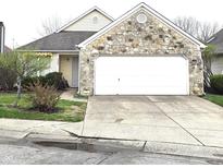 Charming home featuring a two-car garage with stone accents and a well-maintained front yard at 3259 Eddy Ct, Indianapolis, IN 46214
