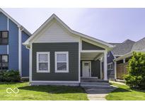 Charming home featuring a covered porch, gray siding and white trim and well-maintained front lawn at 337 E Minnesota St, Indianapolis, IN 46225