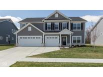Beautiful two-story home with a well-manicured lawn, three-car garage and gray siding for great curb appeal at 4016 Railhead Ave, Westfield, IN 46074