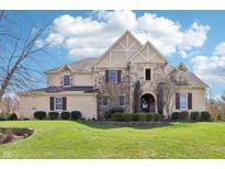Beautiful two-story home with a stone and brick facade, manicured lawn, and professionally landscaped shrubs at 4429 Serengeti Cir, Carmel, IN 46074