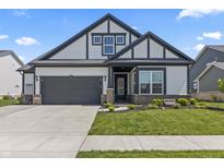 Charming home featuring gray and white colors, complemented by a landscaped front yard and a convenient two-car garage at 15755 Scher Dr, Westfield, IN 46074