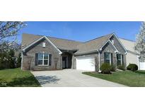 Charming single-Gathering home features a well-manicured lawn, a two-car garage, and blossoming trees in the front yard at 1630 Valdarno Dr, Greenwood, IN 46143